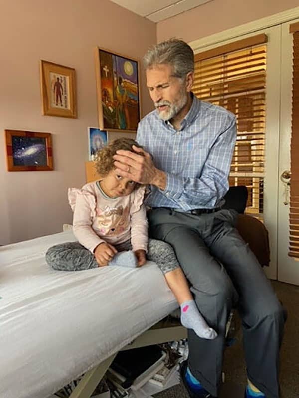 Dr Jorge Moreno practicing osteopathy on a child